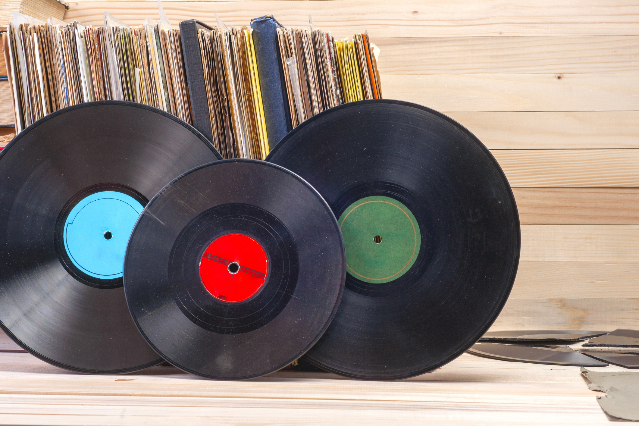 Vinyl record in front of a collection of albums, vintage process.