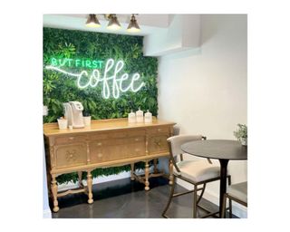 'But first coffee' LED neon sign on faux living wall backdrop