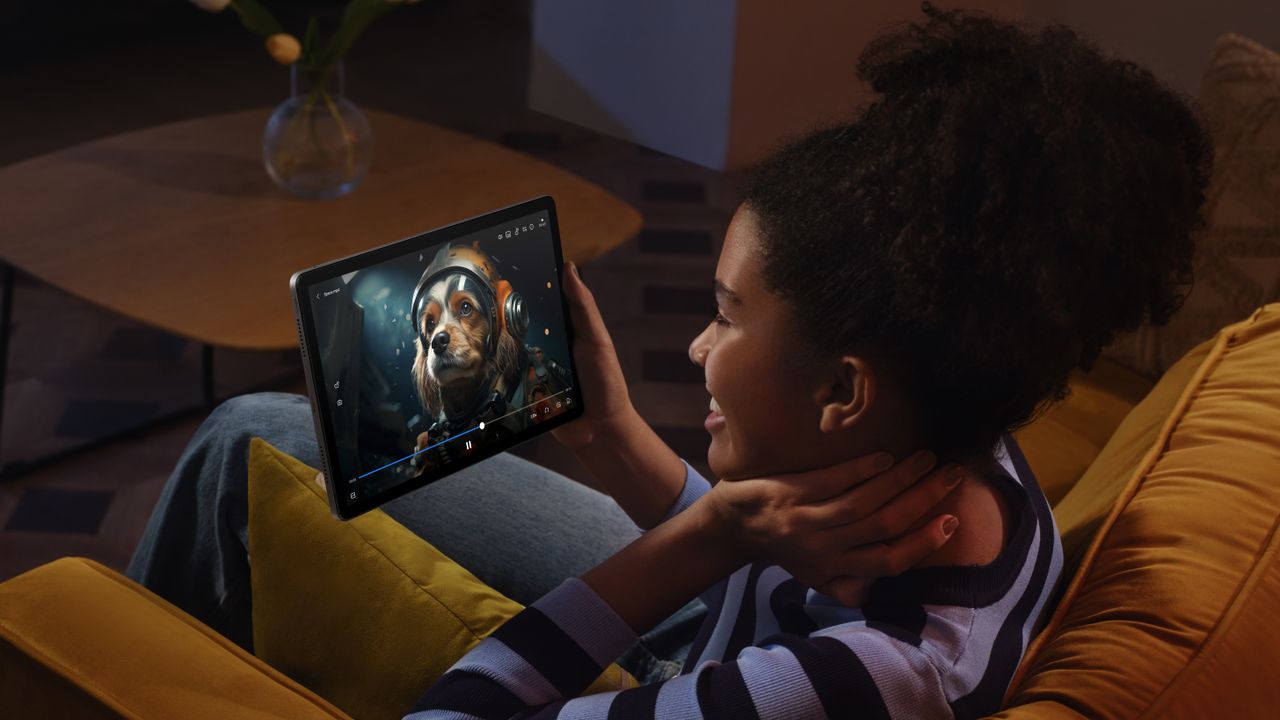 The Redmi Pad SE in use to watch a movie by a person sitting on a sofa