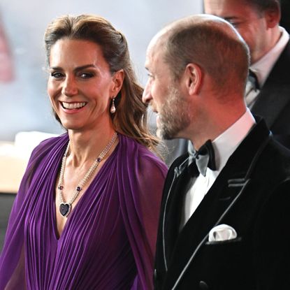 Princess Kate wearing a purple gown with Prince William at the Digger premiere