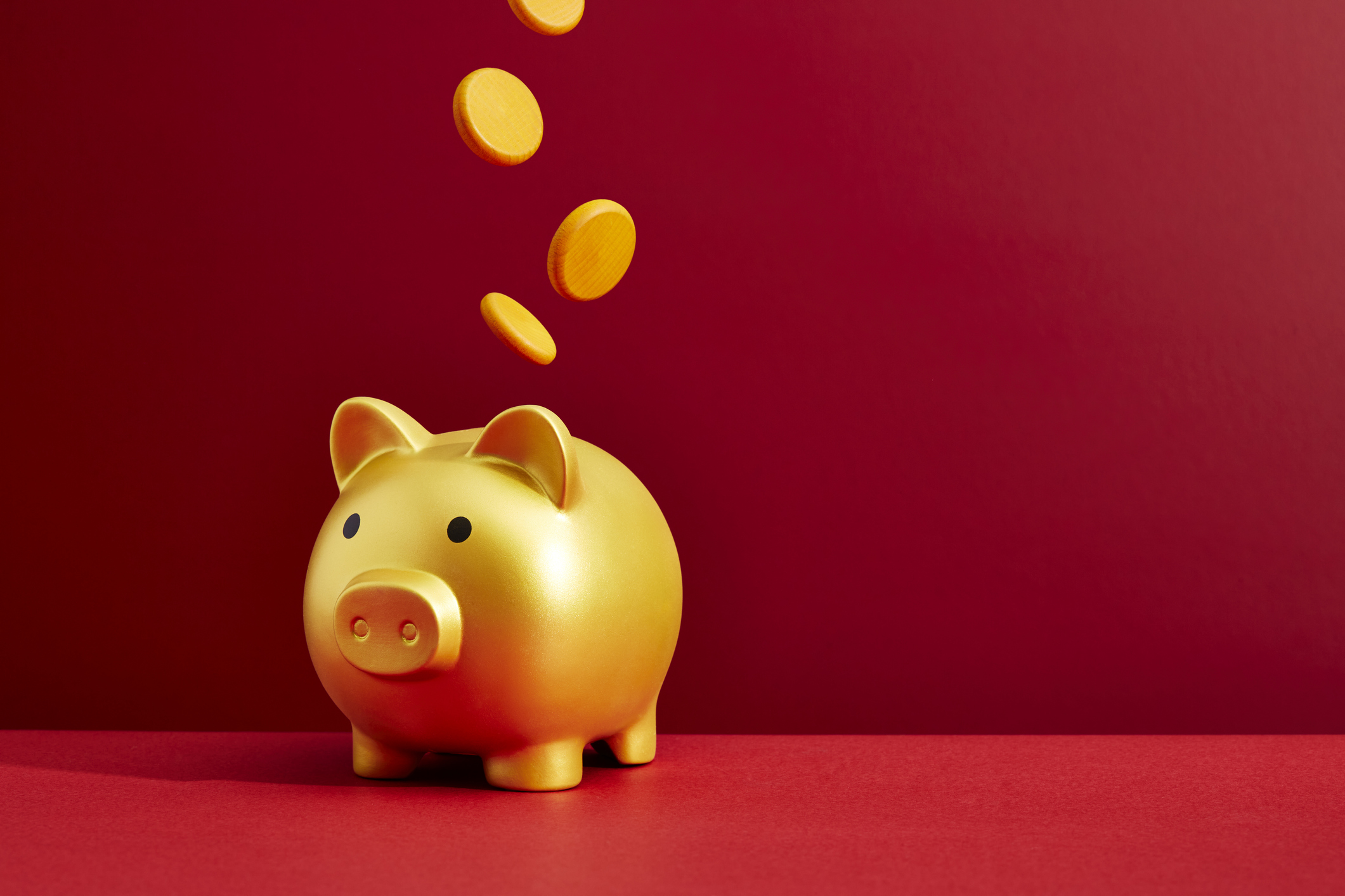 Coins dropping into a piggy bank, cash ISAs concept