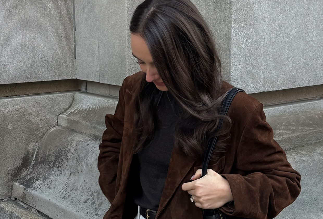 Liv Perez wearing a brown suede Madewell x Alexa Chung trench coat with a black shirt and white jeans.