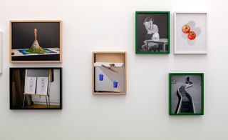 Photographs in different colour frames hanging on a wall.