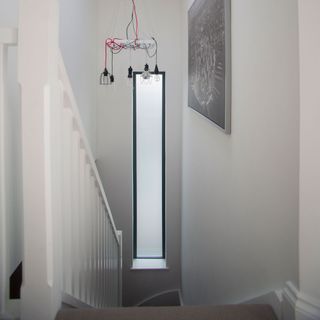 White stairway with a tall narrow window