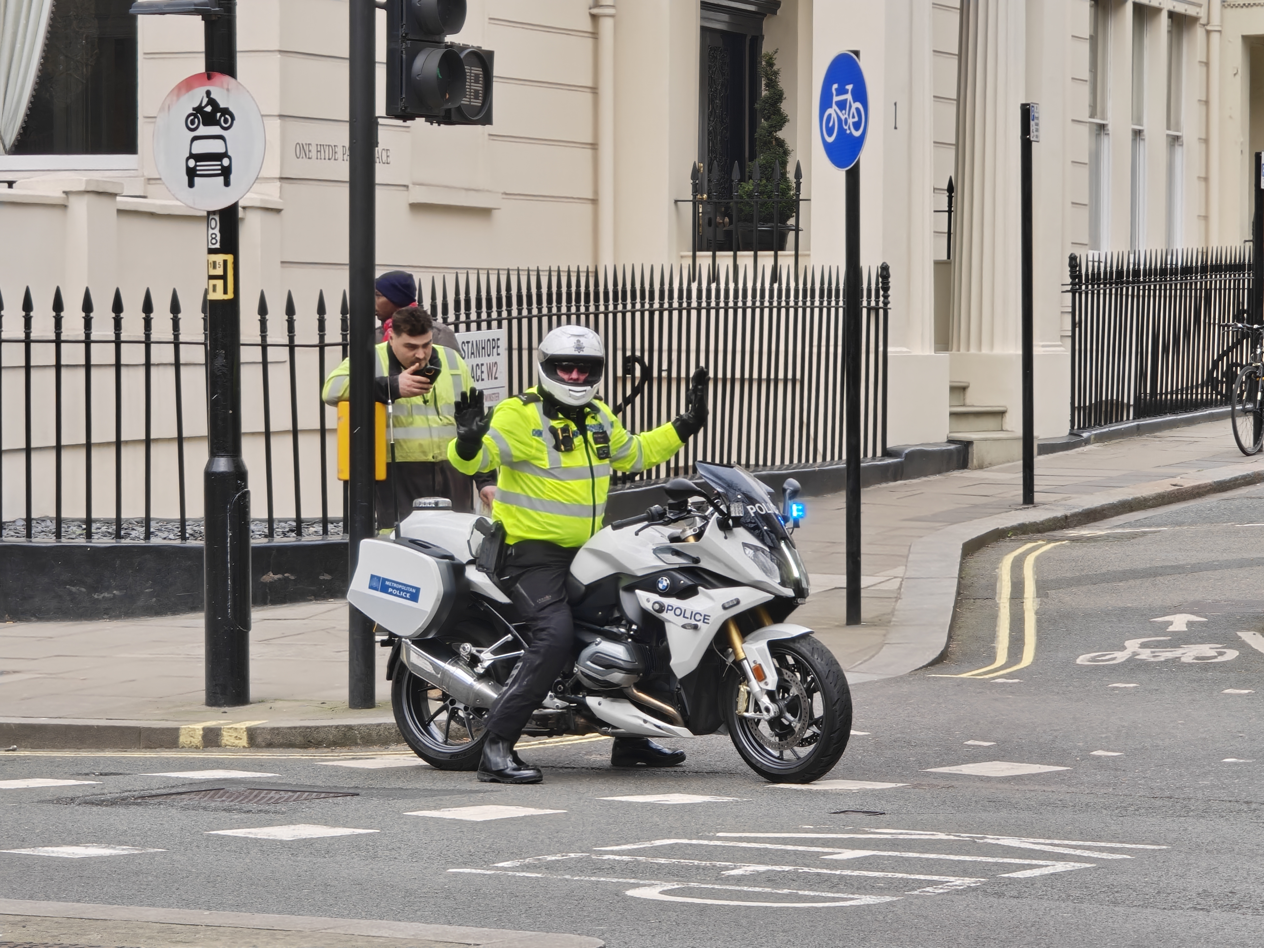 A policeman on a motorcycle stopping traffic