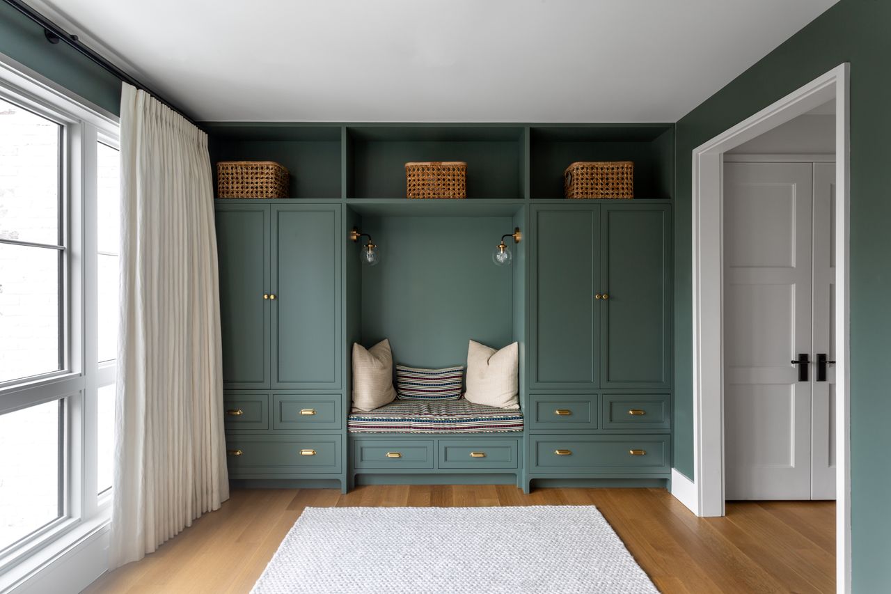 Dark bluey green built-in entryway storage with bench.