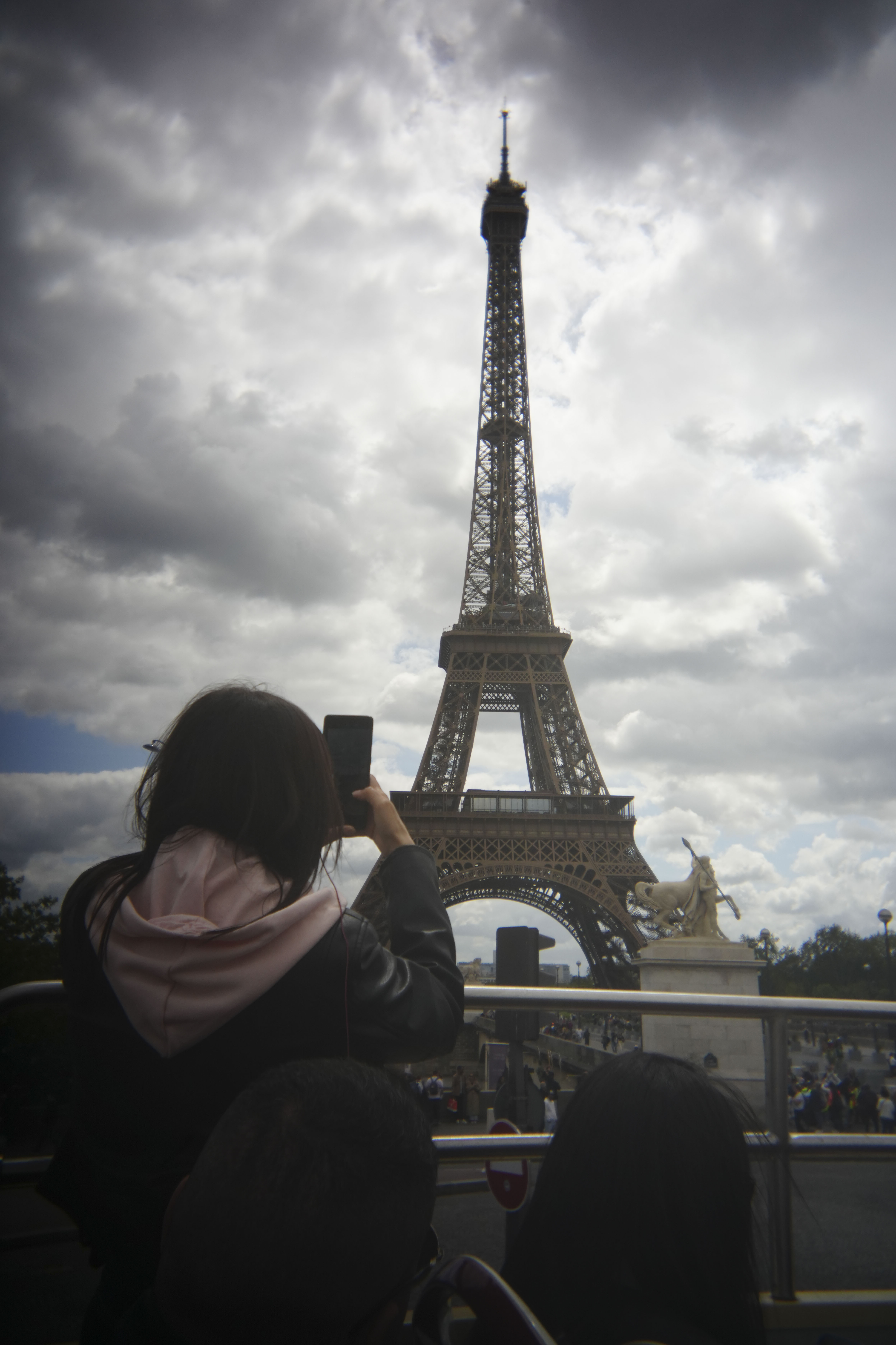 A shot of tourists taking a photo of the Eiffel Tower