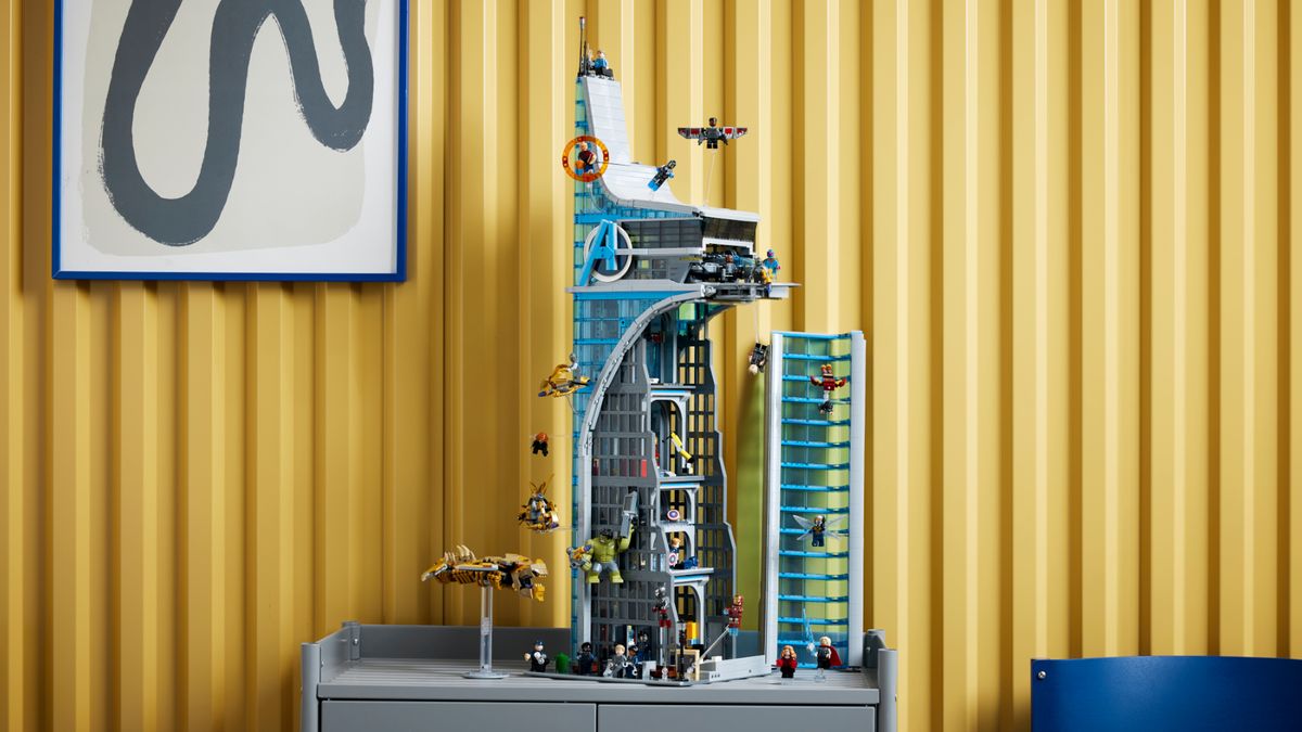 Lego Avengers Tower and its minifigures on a table, in front of a panelled wall