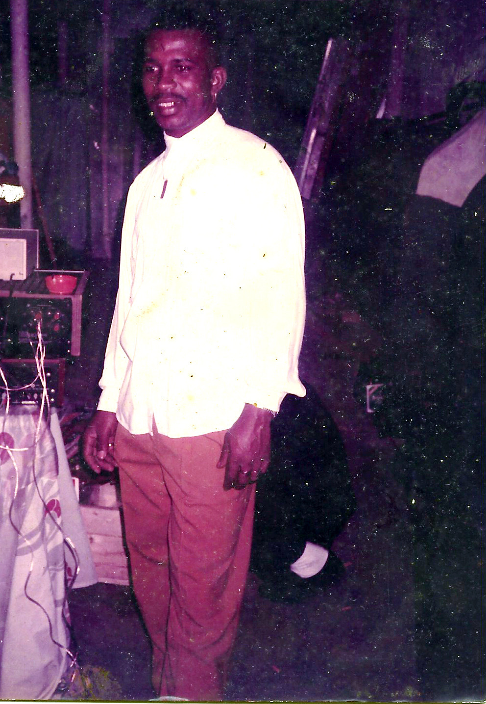 Claudis Carmichael wearing a white shirt, red pants, and grillz.