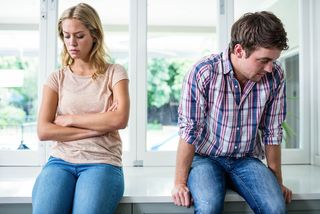 A young couple sits together, mad at each other