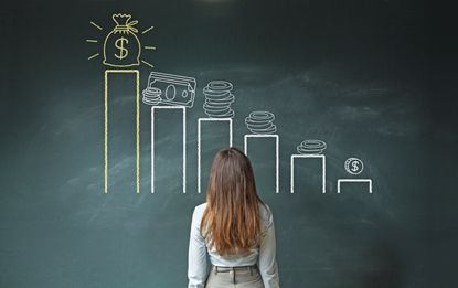 Business woman standing in front of a blackboard with a financial chart