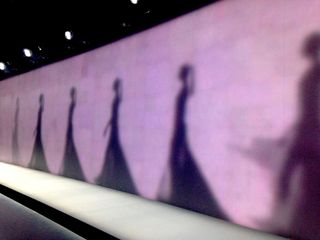 The shadows of models against a purple wall