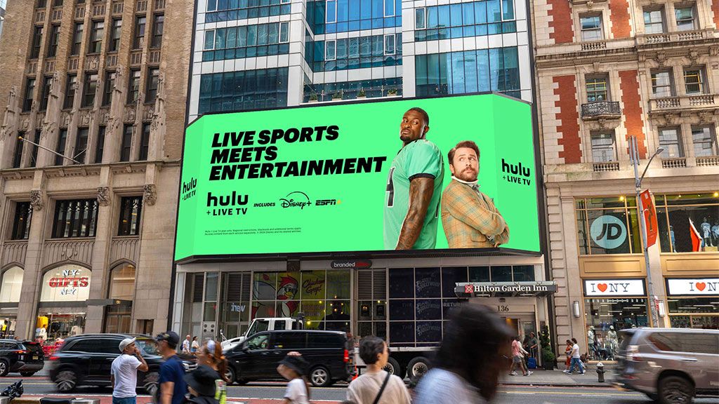 An SNA Display with a Hulu ad sits on the façade of the Hilton Garden Inn Times Square Central, measuring 75.7x27.7 feet tall.