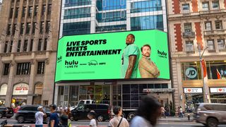 An SNA Display with a Hulu ad sits on the façade of the Hilton Garden Inn Times Square Central, measuring 75.7x27.7 feet tall.