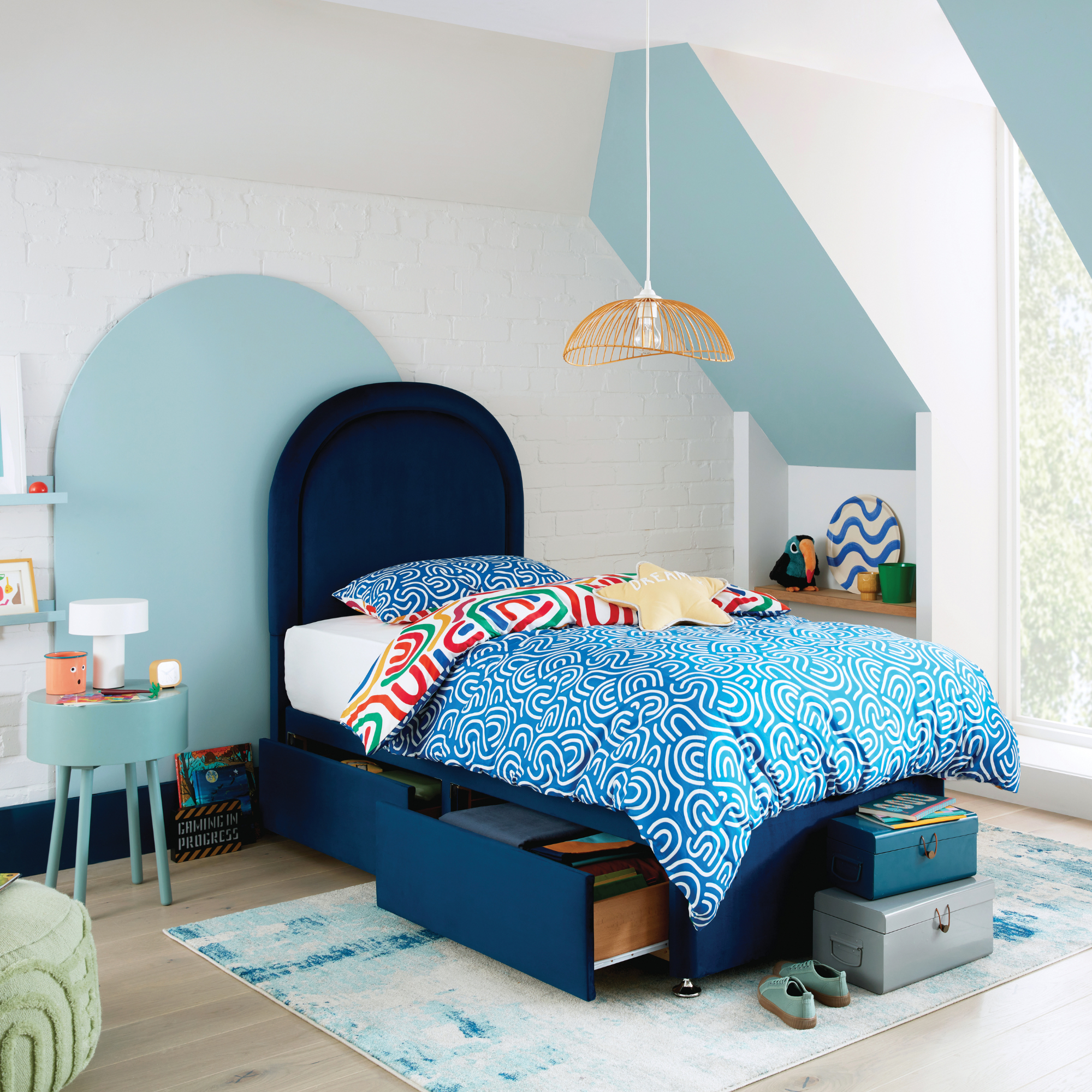 a single blue bed in a kids room with built-in drawers for storage