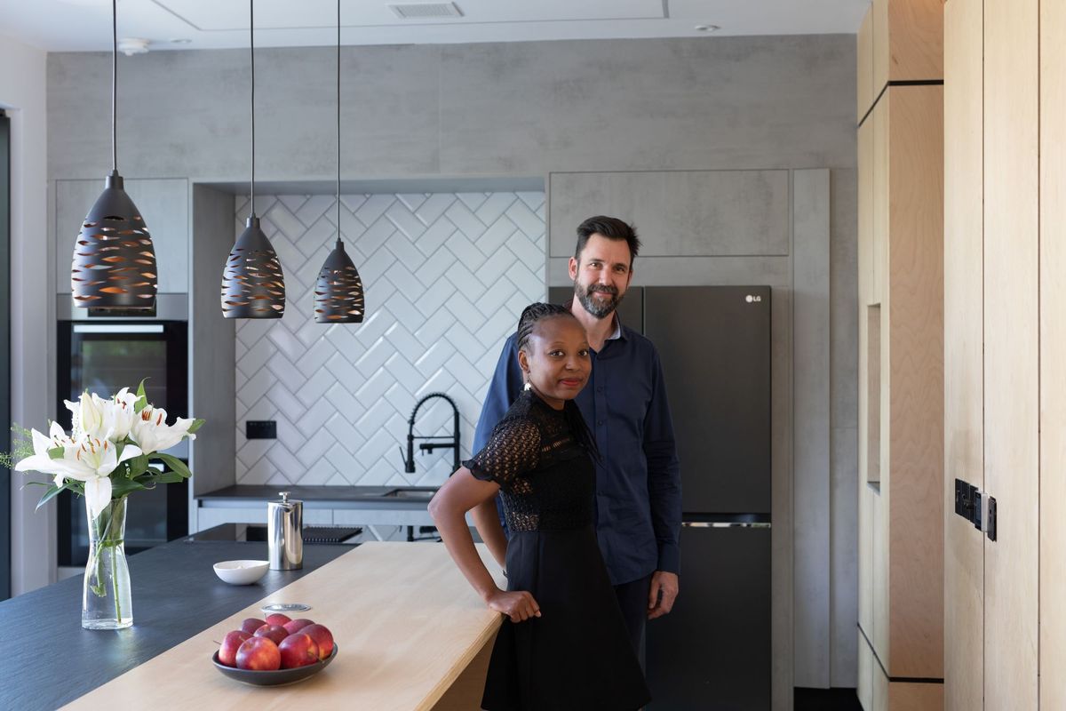 The couple standing beside one another in their new kitchen