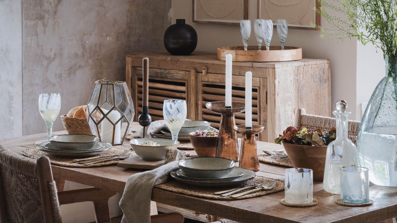 Dining table with candles, candlesticks, glasses, wooden table