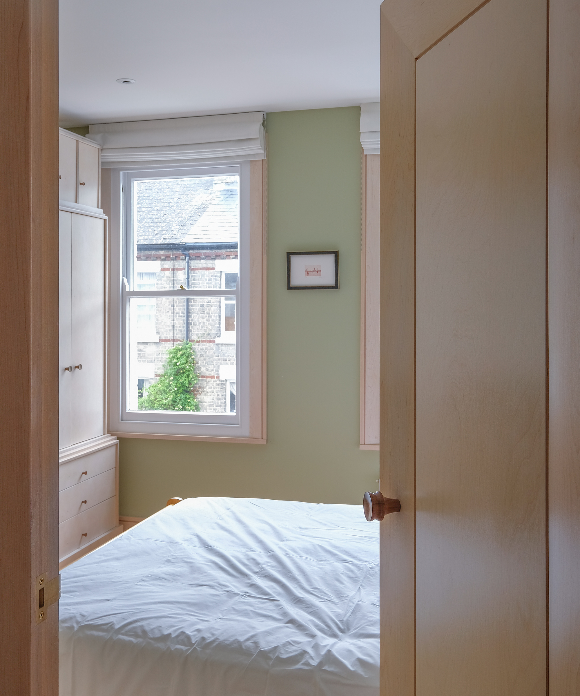 Birch plywood storage and internal door looking into a small double bedroom