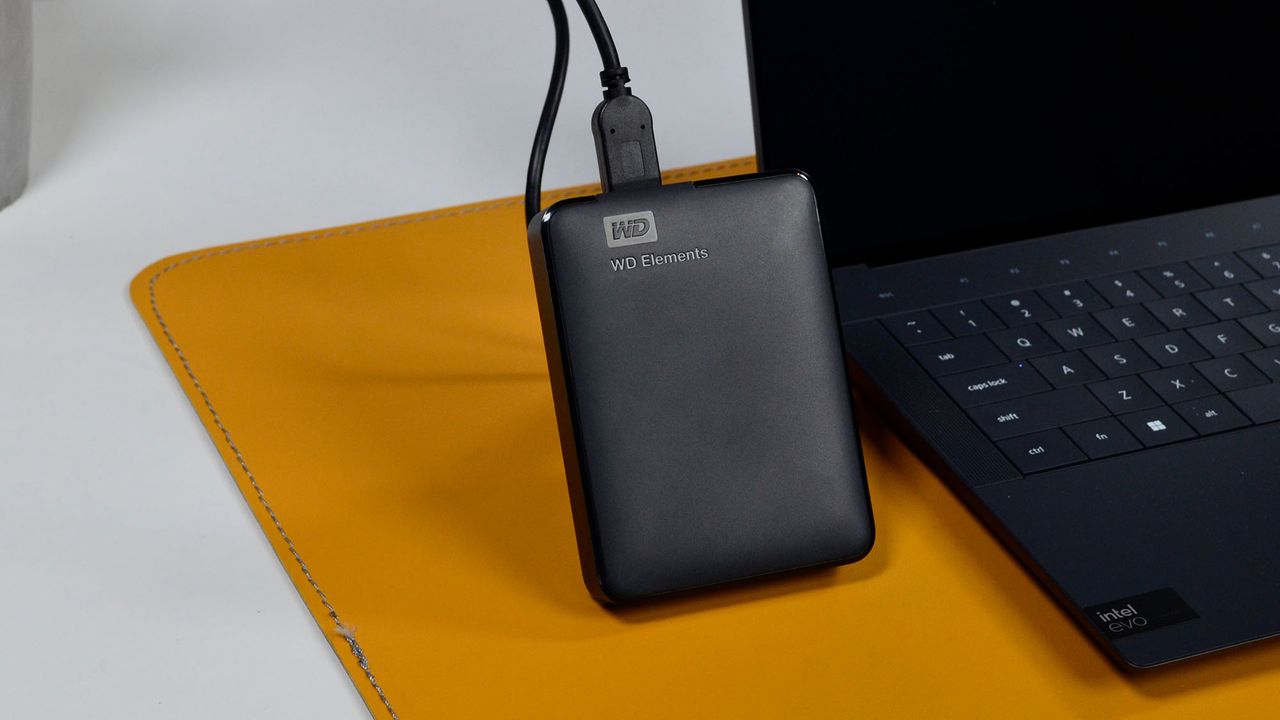 A msculine hand holding a WD Elements external hard drive