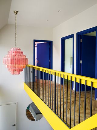 landing with yellow stair rail and blue doors