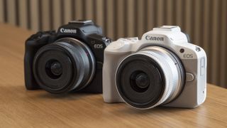 Two Canon EOS R50's on a table in two colors; black and white