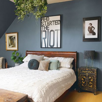 blue master bedroom with wooden bed frame, and white bedroom