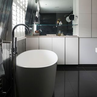 bathroom with black tiles on floor and wash basin