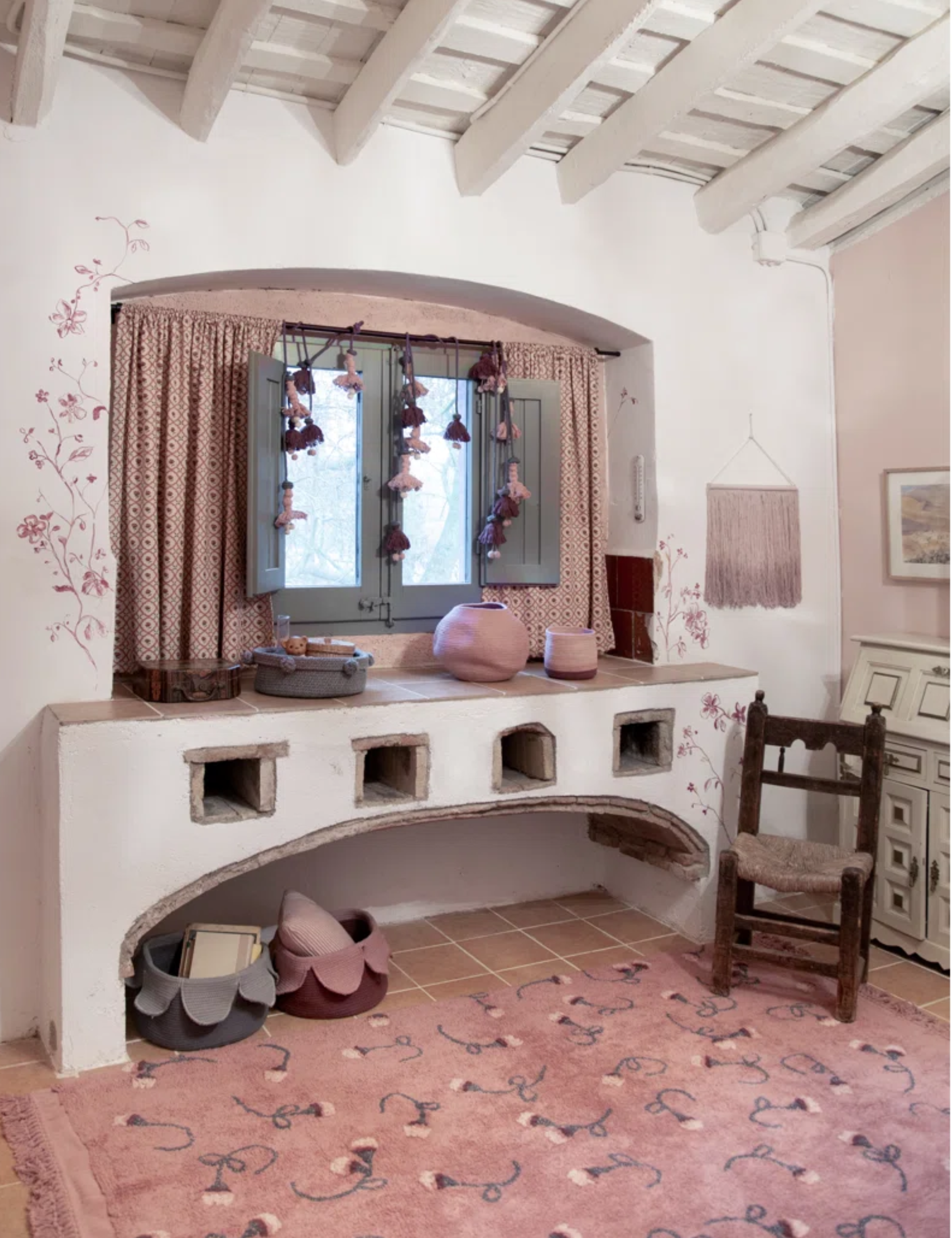 Romantic dressing room area styled with a scattered rose motif rug in blush and vintage furniture