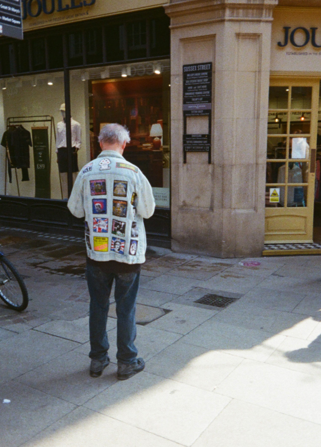 Street photo of a man with patches on his jacket taken with the Kodak Ektar H35 half frame camera