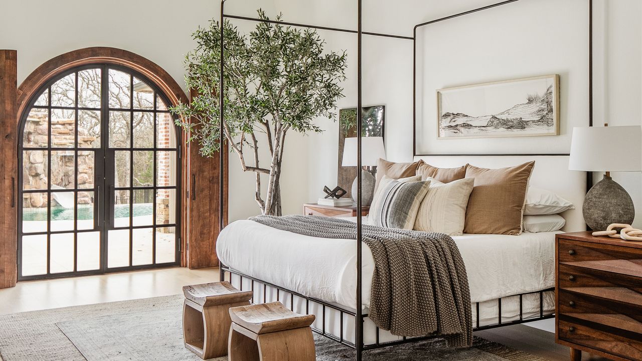 a bedroom with a fourposter bed with wall art