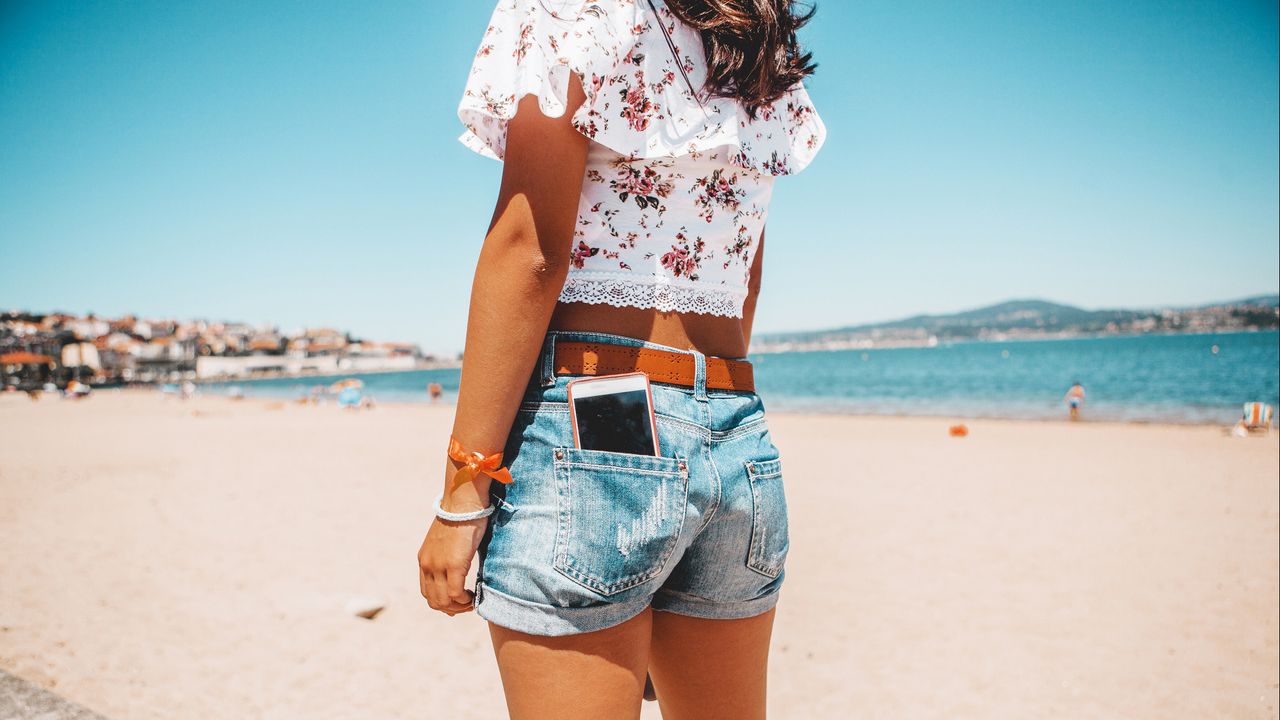 Hot weather, phone in pocket on sunny beach