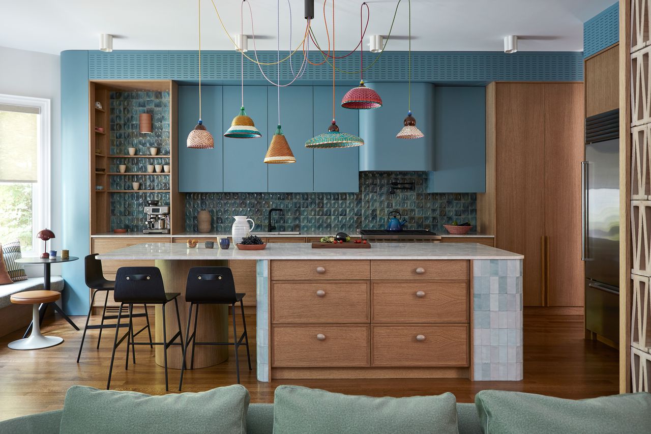 a blue kitchen with colorful pendant lighting and a tile blue and wood island