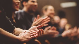 People applauding, from the perspective of hands