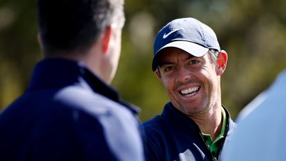 Rory McIlroy smiles while having a conversation