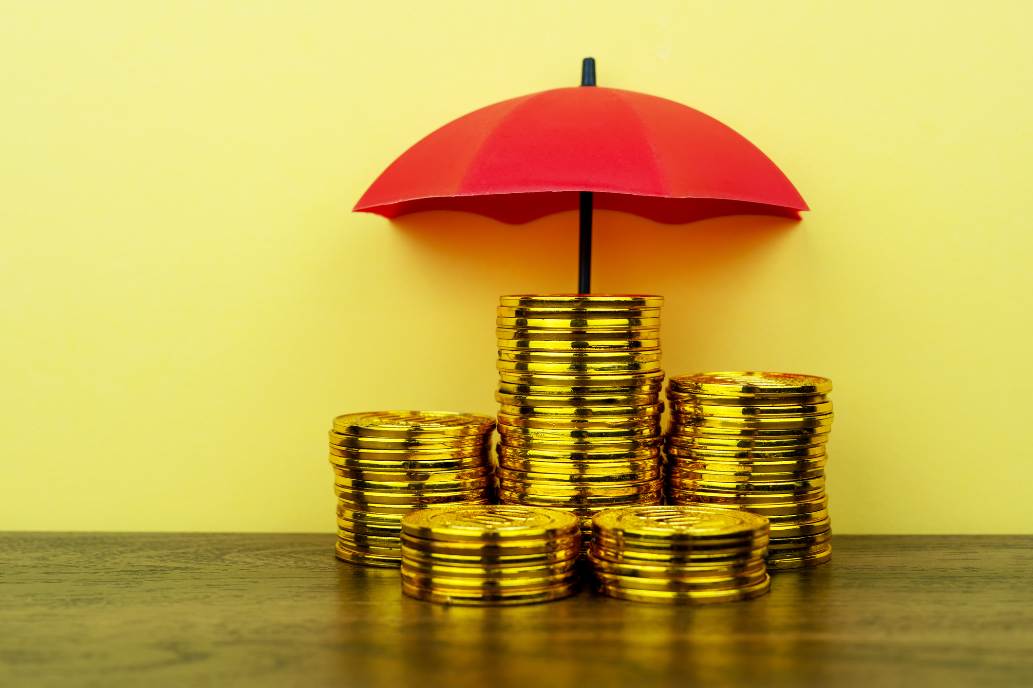 gold coins with a red umbrella over them
