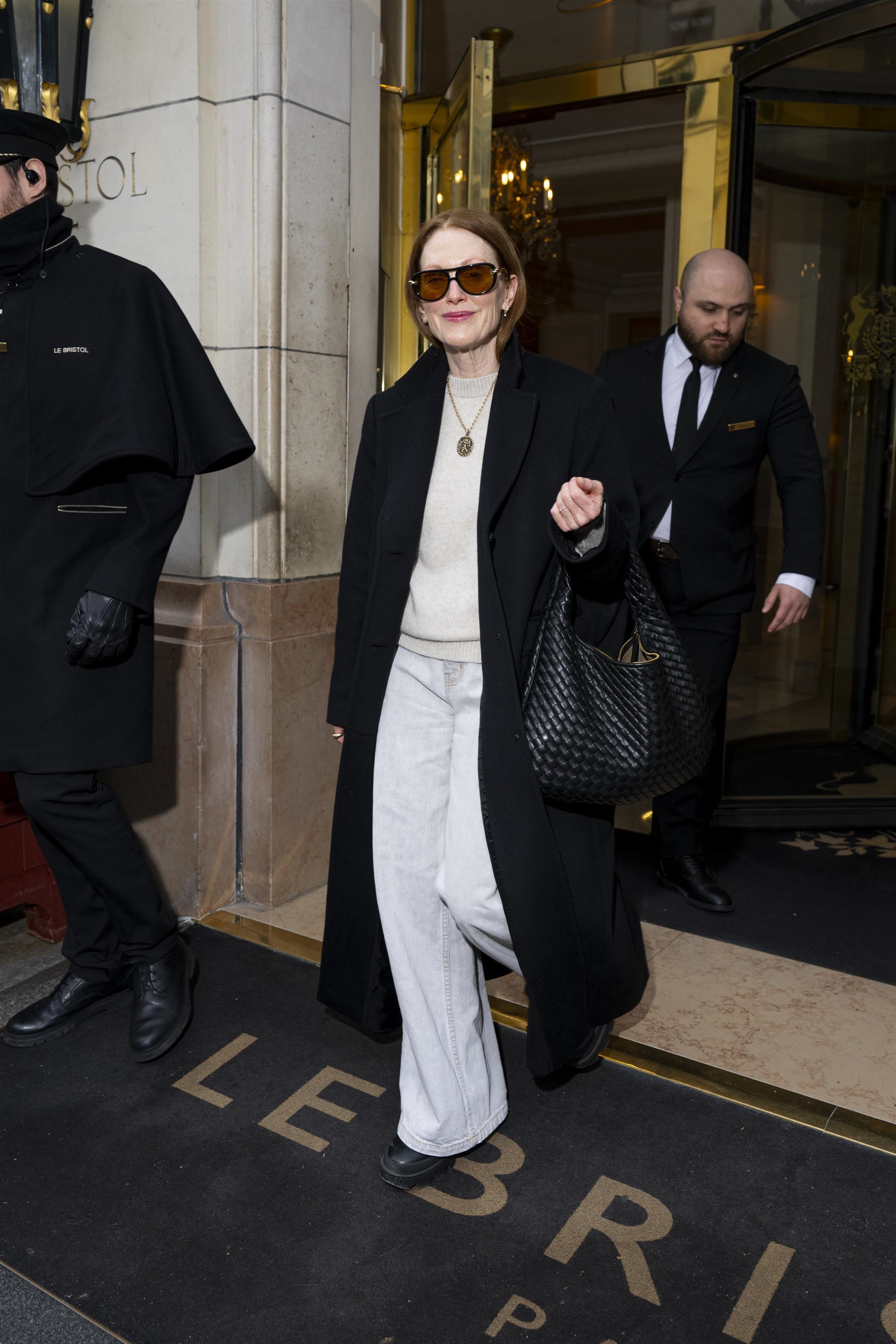 Julianne Moore wears a black coat, grey jeans and carries the Veneta Bottega Veneta bag