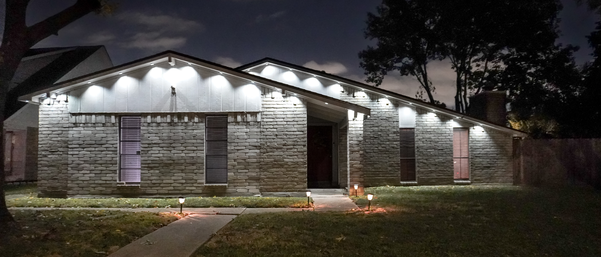 A house with Govee's Permanent Outdoor Lights Prism installed under its roof and set to cool white light