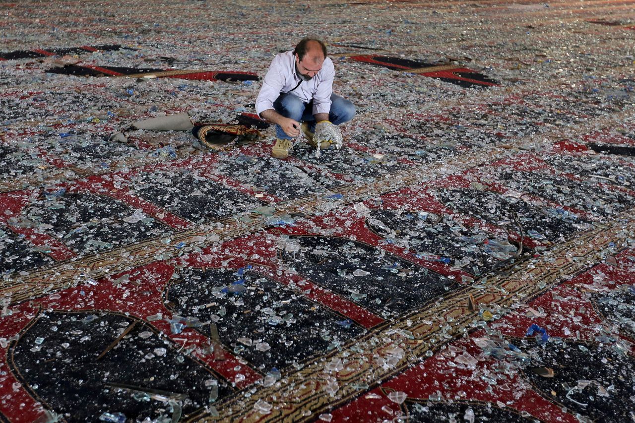 A man cleaning broken glass.