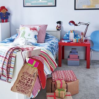 childrens room with cushions on bed and lamp on bedside table