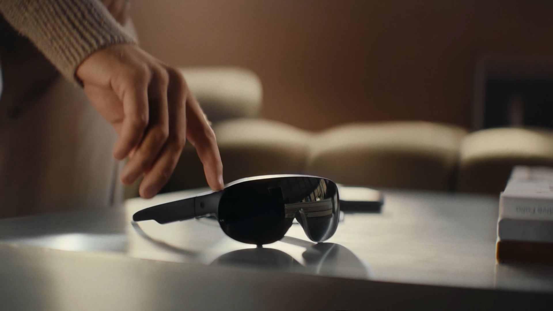 A user picking up Meta's VR glasses from a table