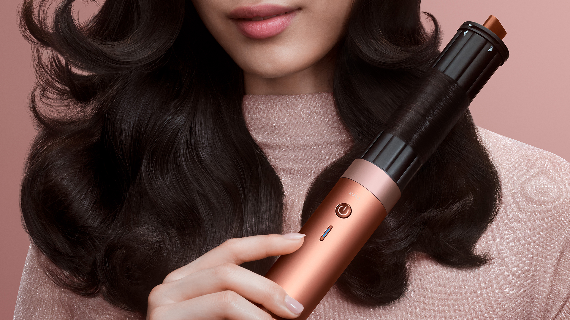 Woman using Dyson hair tool in Amber Silk colorway