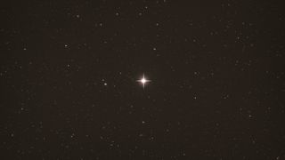 A bright star in the center of the screen against the dark background of space.