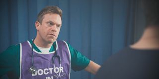 William Beck as Dylan Keogh wearing a special bib indicating he's a doctor in this shocking emergency situation.