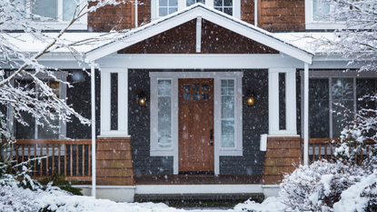 Snow falling across the exterior of a house 