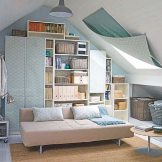 Storage and seating area in a converted loft with sloping ceilings and a stylish cover over the roof window