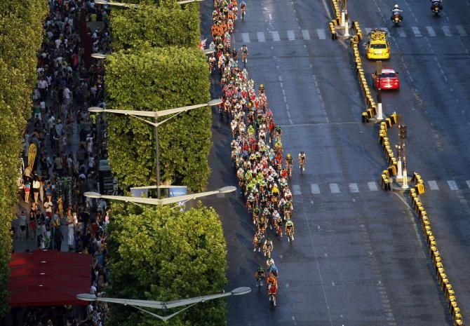 The peloton ride into the setting sun on the Champs &Eacute;lys&eacute;es