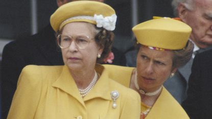 Queen Elizbeth II, Princess Anne and Henry Herbert, 7th Earl of Carnarvon (1924-2001), racing manager to Queen Elizabeth II, watching the horseracing at the Derby meeting, at Epsom racecourse, in Epsom, Surrey, England, Great Britain, 1 June 1988. The Queen is wearing a yellow hat trimmed with white flowers, designed by milliner Frederick Fox. 