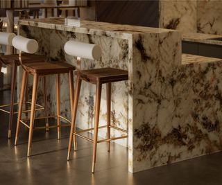 brown and white marble kitchen island with raised rear section and barstools