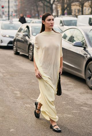 a street style photo of a woman wearing no-show underwear under a yellow sheer dress