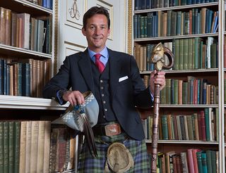 Torquhil Campbell, the Duke of Argyll, and chief of Clan Campbell, in the library of Inveraray Castle. The stick has a wild boar's head carved into it; this is the emblem of the Clan Campbell. (©Country Life/Robert Perry) Picture Robert Perry for Country Life 14th August 2018